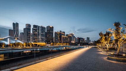 Modern city skyline at dusk with illuminated pathways