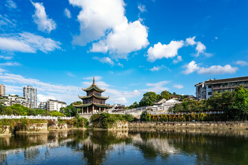 Traditional Chinese pavilion by the calm lake under a clear blue sky