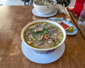 Traditional Peruvian caldo de cabeza soup with lamb