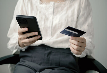 Office lady shopping after work, holding credit card to shop online at work