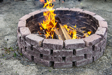 Stone Fire Pit with Burning Wood in Outdoor Garden