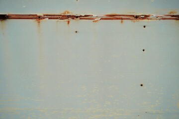 visible rust stains along the top seam and a few small rusted screw holes scattered vertically. The...