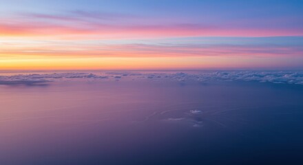 Fototapeta premium A breathtaking aerial view of a pastel sunrise over a vast expanse of clouds, showcasing soft, blended colors and a serene atmosphere.