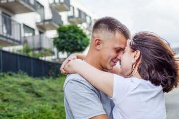 Fototapeta premium In love happy young couple hugging tenderly outdoors, enjoying a romantic moment together.