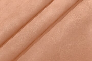 Soft, peach-toned fabric in gentle folds