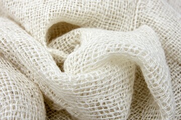Cream-colored woven fabric, loosely draped, showing texture and weave