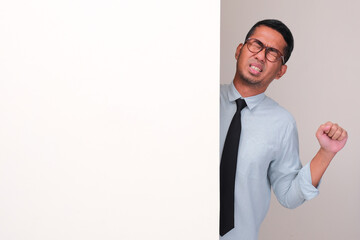 Office employee peeking behind a wall showing tired gesture