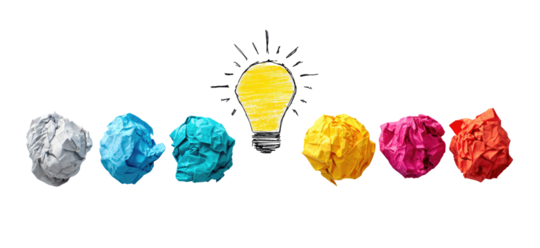 Crumpled paper balls in various colors line up next to a lightbulb, signifying brainstorming and ideas