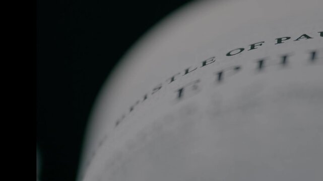 A shallow depth of field shot focusing on a specific verse in the Holy Bible. The clip evokes a sense of study, devotion, and finding meaning in the sacred text.
