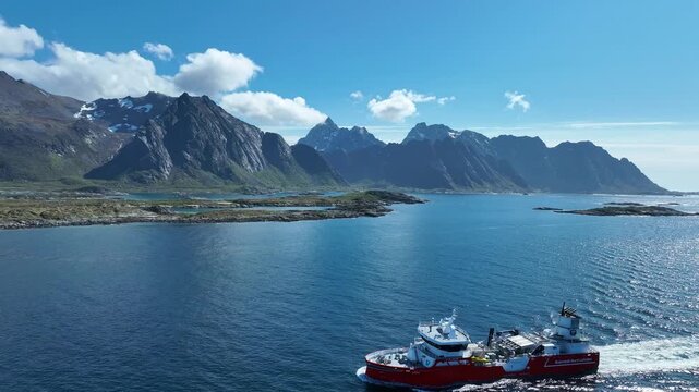 Drone circles close to wellboat as it sails through Gimsoystraumen with Hartinden ahead