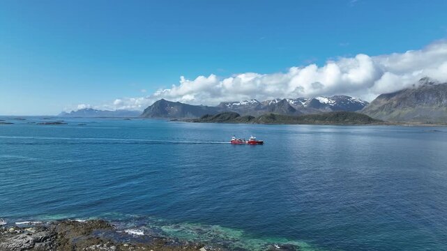 Well boat moves in Gimsoystraumen, passing shoreline and fj&aelig;re before sailing with Lofoten peaks