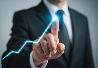 Businessman's finger touches glowing upward trend line signifying business growth and success