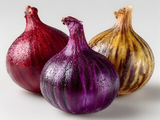 Obraz premium Three colorful onions, including red and purple varieties, glisten with freshness on a bright white surface.