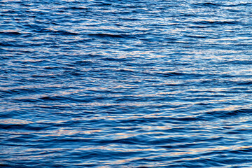 Water background texture. Waves at sunset.