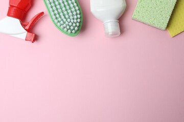 Flat lay with cleaning supplies including bottle, sponge, spray on pastel background. Top view