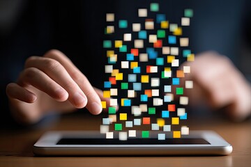 Hands interacting with a tablet displaying colorful, pixelated data