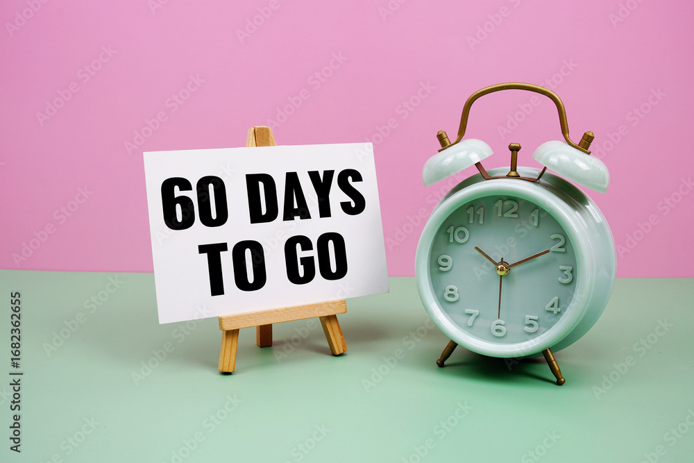 Poster 60 days to go text with alarm clock on pink and green background