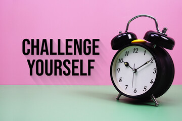 Black alarm clock on a pastel green and pink background with the text 