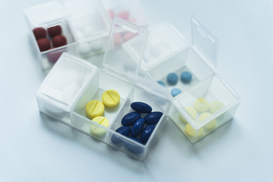 Assorted of medicine or pill with weekly pill organizer or box on table. Concept of daily medication routine, chronic care, health management, and disciplined self care lifestyle.