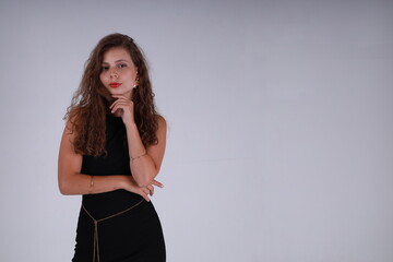 Portrait of pretty curly brunette woman in black dress