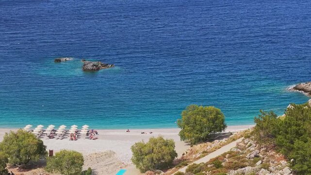 Smooth parallel drone movement along Achata Beach in Karpathos, Greece, revealing its shoreline