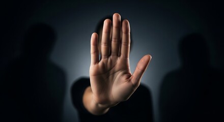 A person's hand raised in a stop gesture, with a blurred face and shadowy figures in the background, conveying a sense of warning or refusal.