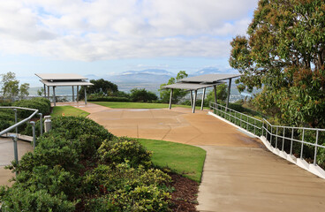Concrete path leading to viewing pavilions surrounded by plants and trees at the Castle Hill...