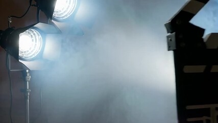 Action! Professional film clapperboard illuminated by dramatic stage lights and smoke creating cinematic atmosphere