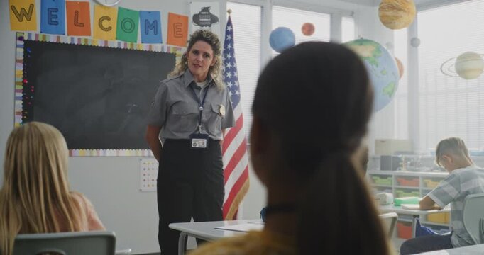 Female TSA Security Officer Explaining Safety Rules to Young Students at American Elementary School. Children Sitting, Listening to Police Worker Guidance About Knowledge of Law and Responsibility.