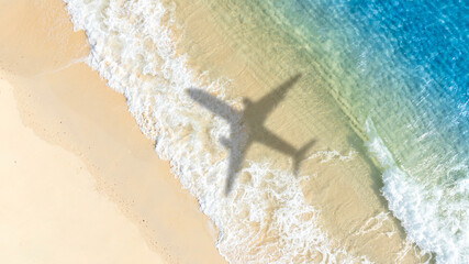 Aerial view of shadow passenger plane silhouette and sandy beach blue sea with waves at sea beach summer vacation sea travel concept	