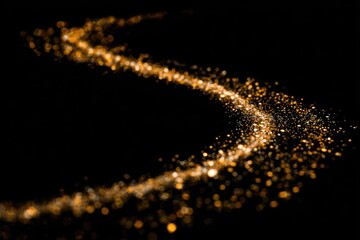 Golden sparkles swirl on black background