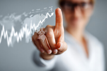A businesswoman pointing at a virtual financial chart