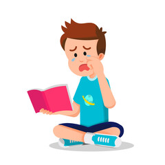 A boy sits on the floor reading a book with a sad expression and tears in his eyes