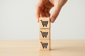Hand Stacking Wooden Blocks with Shopping Cart Symbols on a Minimalist Background for E-commerce Concept and Online Shopping Illustration