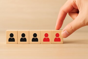 Hand Selecting Red Person Icon Among Blocks Representing Team Members Diversity and Choice in Modern Workplace or Community Settings