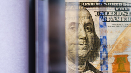 Close-up of US dollar with layered reflections, symbolizing unlimited money printing and QE policy. Concept of inflation, global crisis, economic imbalance, and devaluation of currency.