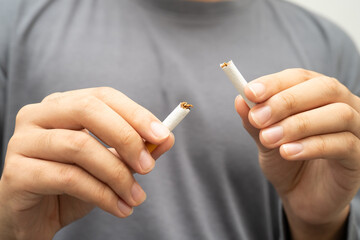 Quit smoking, Asian teenage man breaking destroy cigarette in hand.