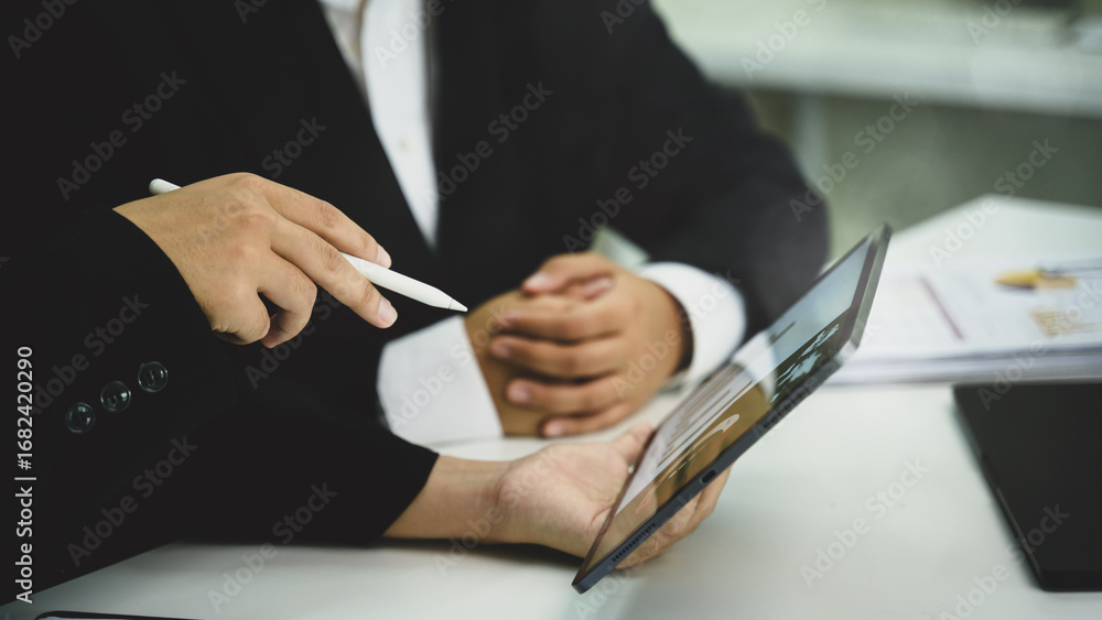 Poster colleagues analyzing financial data and workflow charts with digital tablet in an office