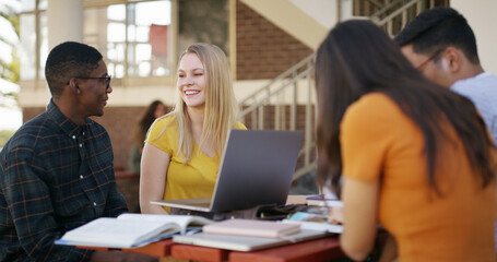 Laptop, group and people in library with studying for college exam, test or assignment together. Computer, happy and students with education for assessment with teamwork at university campus.
