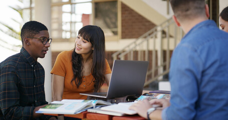 Library, friends and group with laptop, discussion or research for exam on web, learning and online. Studying, students and people with tech in university, plan and test preparation with knowledge