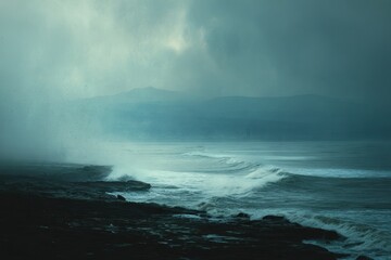 Obraz premium Serene Coastal Landscape Amidst Misty Weather and Rolling Waves
