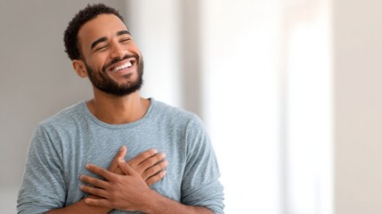 A joyful man with a beard smiles brightly, radiating happiness and positivity in a bright, modern environment.