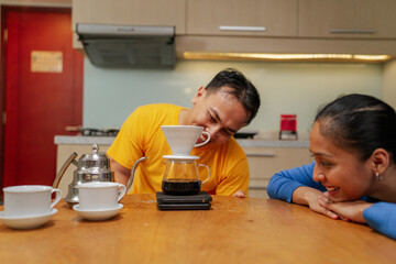 A joyful couple happily engaging in the delightful art of coffee brewing together at home