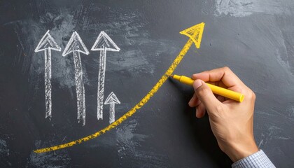 A hand draws a vibrant yellow upward-pointing arrow with a marker on a dark textured surface, showing upward movement and growth, with gray arrows behind