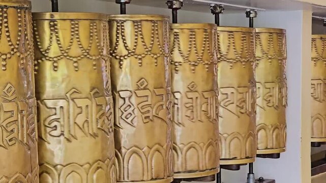 Row of Ornate Mani Wheels with Intricate Carvings
