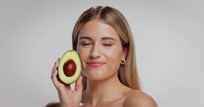 Dermatology, avocado and face of woman in studio with beauty, natural and moisturizing benefits for health. Mockup space, portrait and person with fruit for glow with skincare by white background.