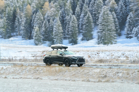 Black SUV traveling on snow-covered rural road - Powered by Adobe