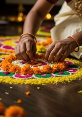 Woman hands creating a colorful floral pattern on the floor for a traditional Onam celebration in India. Festive ritual for Happy Onam festival of South India Kerala. 