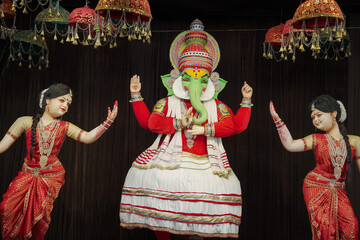 Obraz premium Ganesh in traditional dance attire, Cultural Ganpati with dancers, Artistic Ganesha stage performance, Decorative Ganesh idol with dance theme Stock Photo.