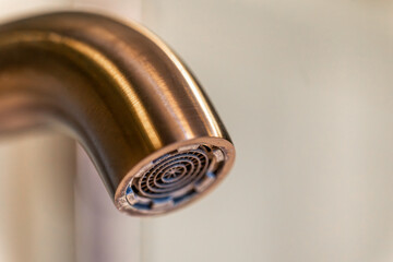 Aerator closeup. Copper glow. Modern faucet.